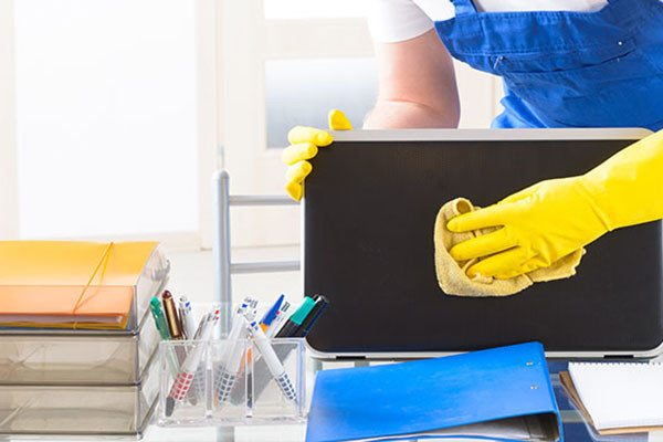 A person cleaning on office desk