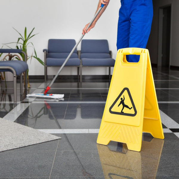 worker cleaning a office floor with a mop